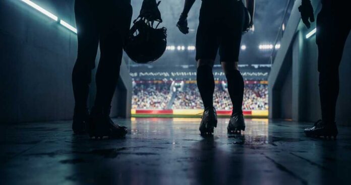 shutterstock_2599720131.jpg Football players standing in a tunnel before entering the stadium