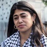 Close-up portrait of a woman in an urban environment wearing a patterned scarf