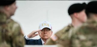 A man in a USA hat saluting during a military ceremony