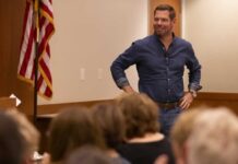 A speaker in a denim shirt engaging with an audience