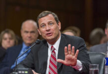 A man in a suit speaking during a formal hearing