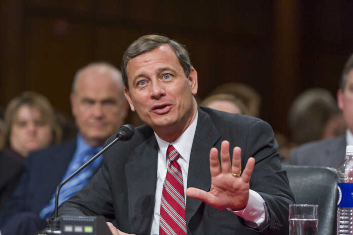 A man in a suit speaking during a formal hearing