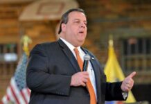 A man in a suit speaking into a microphone at an event