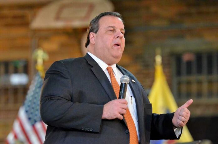 A man in a suit speaking into a microphone at an event