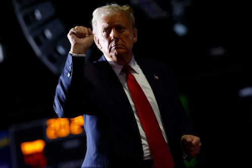 Person with raised fist in dark background.