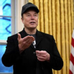 Military Tech Breach? Musk’s Alarming Allegation Man wearing hat gesturing in room with flag