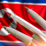 Pyongyang’s Missile Moves: A Calculated Game? Missiles in front of a North Korean flag
