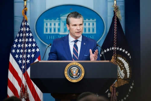 pete-hegseth2586172231jpg Man speaking at podium with flags in background