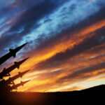 Russia’s Secret Weapon Sparks Kyiv Panic Silhouette of missiles against dramatic sunset sky.