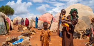 Children in a makeshift camp on a dry, dusty ground