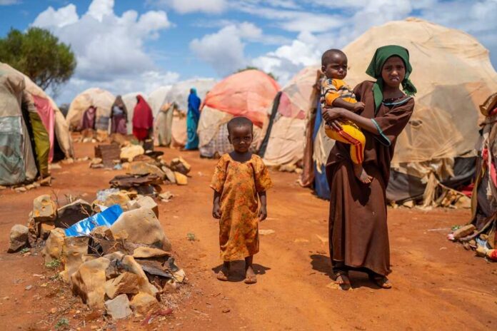 Children in a makeshift camp on a dry, dusty ground
