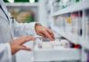 Pharmacy Ripoff EXPOSED: Stunning Price Gap Pharmacist organizing medication on a shelf