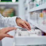 Pharmacist organizing medication on a shelf