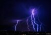 Multiple lightning strikes illuminating a dark night sky
