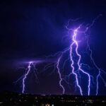 Multiple lightning strikes illuminating a dark night sky