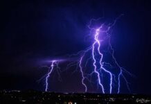 Multiple lightning strikes illuminating a dark night sky