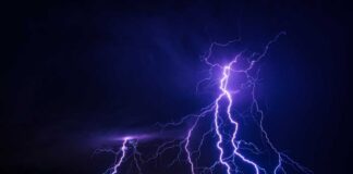 Multiple lightning strikes illuminating a dark night sky