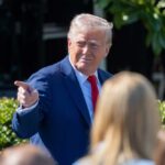 Mental-Health War on Trump: Truth or Tactics? A man in a blue suit and red tie gestures while speaking to a crowd