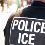 Close-up of a police officer's back with a 'POLICE ICE' badge