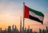 United Arab Emirates flag waving in front of a city skyline during sunset