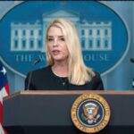 Cancer Shock: Ex-AG’s Secret Battle Unveiled! A government official speaking at a podium in front of the White House seal