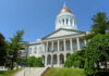 Exterior view of a historic government building with a dome and columns