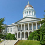 Exterior view of a historic government building with a dome and columns