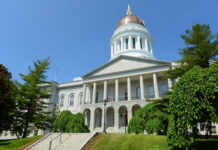 Exterior view of a historic government building with a dome and columns