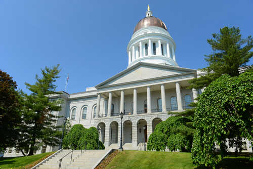 Exterior view of a historic government building with a dome and columns