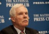 Billionaire Passes – How He Changed TV Forever A man with gray hair and a mustache sitting at a press conference
