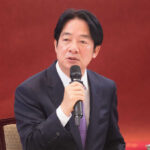 A man speaking into a microphone indoors