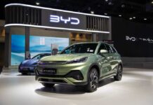 A green BYD Atto 3 electric vehicle displayed at a car exhibition