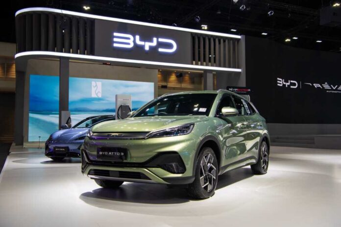 A green BYD Atto 3 electric vehicle displayed at a car exhibition
