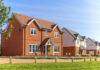 Could Property Taxes Soon Disappear? Red-brick suburban house in a sunny neighborhood.