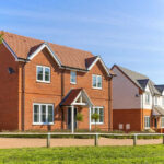 Could Property Taxes Soon Disappear? Red-brick suburban house in a sunny neighborhood.