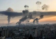 Heavy Machinery Yard Turned War Zone Smoke rising over cityscape at sunset; two birds flying.