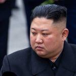 A political figure in formal attire with a serious expression