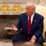 Election ID Or No Spies — Trump Dares Congress A man in a blue suit and red tie gesturing during a discussion in a formal setting