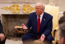 Election ID Or No Spies — Trump Dares Congress A man in a blue suit and red tie gesturing during a discussion in a formal setting