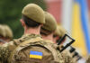 Soldiers with backpacks and Ukrainian flags in formation
