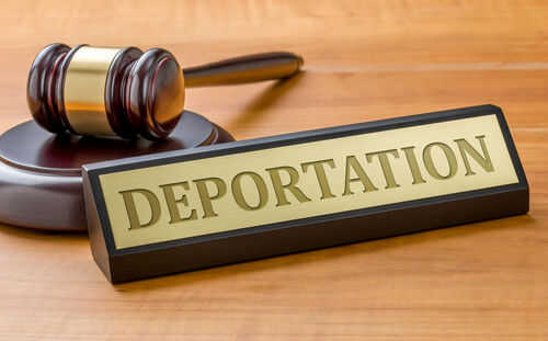 Gavel and sign reading Deportation on desk.