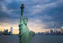 Record Welfare Spending Demands Accountability Statue of Liberty with city skyline at dusk