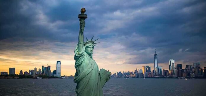 shutterstock_1157154073 Statue of Liberty with city skyline at dusk