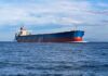 The Hidden Iran Tax At Every Gas Pump A large cargo ship sailing on the ocean under a blue sky