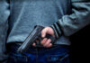 Domestic Orders Trigger Ban—But How Far? Person holding a handgun behind their back
