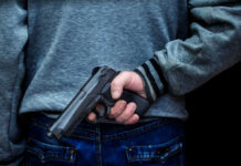 Domestic Orders Trigger Ban—But How Far? Person holding a handgun behind their back