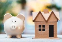 What’s Really Behind Sky-High Home Prices? Piggy bank beside cardboard house model on a table