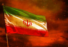 Diplomacy Or Deterrence—Time’s Running Out Iranian flag waving against a dramatic orange sky
