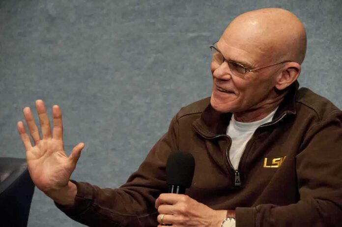 Bald man speaking into a handheld microphone