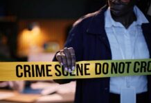 Police officer holding crime scene tape